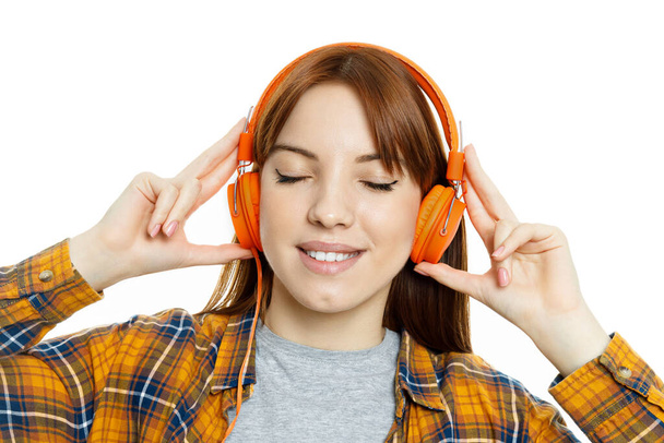 Έννοια των ανθρώπων, νεαρή γυναίκα με ακουστικά που απομονώνονται σε λευκό φόντο - Φωτογραφία, εικόνα