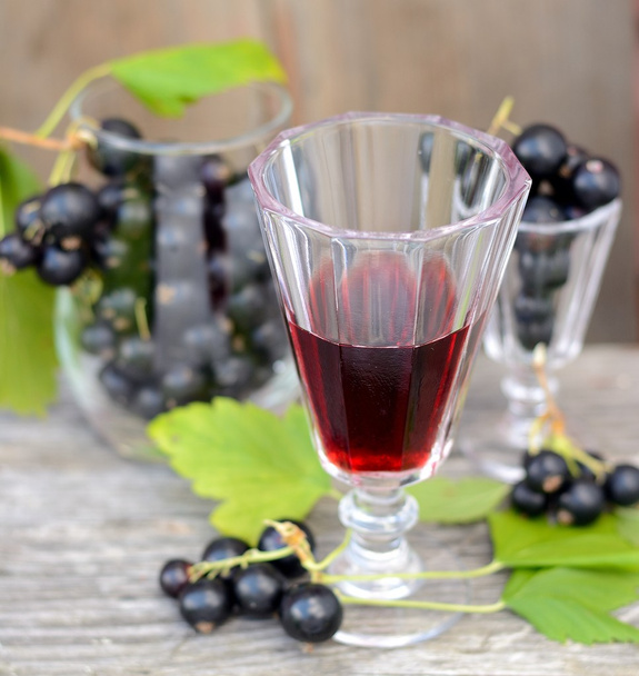 black currant liquor and ripe berries  on  wooden table - 写真・画像