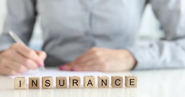 Agente de seguros escribe declaración en la tabla a mano. Agente o corredor de seguros de vida. Planificación de pólizas de seguros y concepto de gestión de condiciones comerciales - Metraje, vídeo