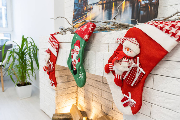 Різдвяні шкарпетки для подарунка Миколая звисають над каміном у будинку. - Фото, зображення