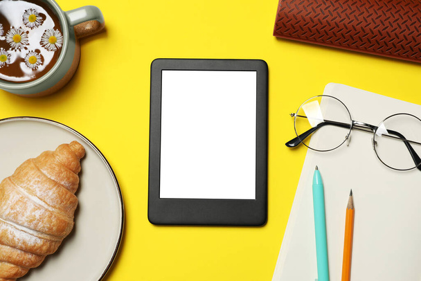 Flat lay composition with modern e-book reader on yellow background - Valokuva, kuva