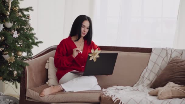 Una joven está sola en Navidad, pero usa su computadora portátil para contactar a su familia en Internet. - Imágenes, Vídeo