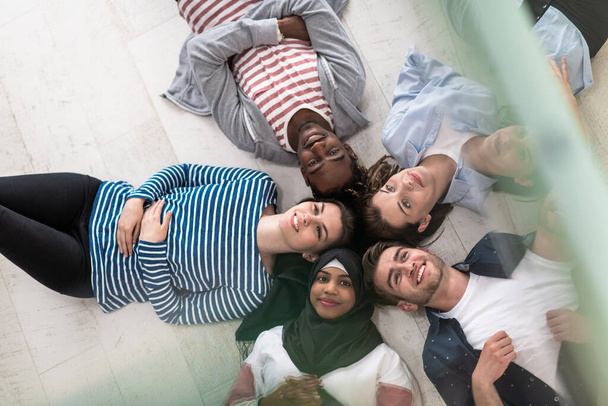 Top view of a diverse group of people lying on the floor symbolizes togetherness. High quality photo - Foto, Bild