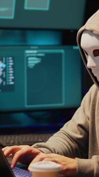 Vertikální video: Hacker s anonymní maskou porušující bezpečnostní systém, instalace viru vytvořit počítačový malware a krást on-line data. Maskovaný kriminální podvodník hackerský síťový server pozdě v noci. - Záběry, video