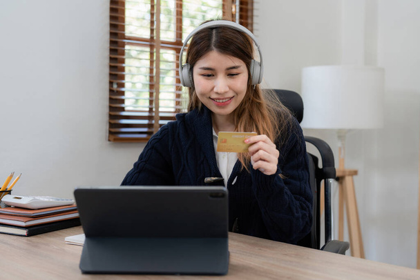 Young person using credit card and laptop computer. Online shopping, e-commerce concept. - Foto, Bild