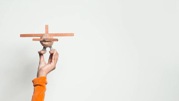 Wooden toy airplane in hand on white background - 写真・画像