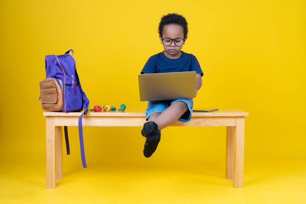 Cute little boy uczenia się Internetu lub grając w gry z jego laptopa, aby zwiększyć wyobraźnię. - Zdjęcie, obraz