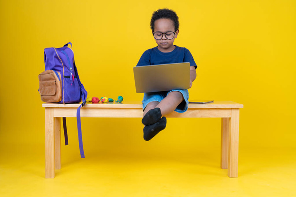 Cute little boy learning the internet or playing games with his laptop computer to enhance imagination. - 写真・画像
