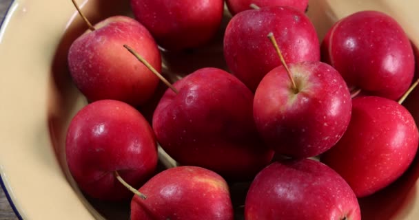 Kis piros ősz eper alakú alma vágott szelet mag zománc fém lemez rusztikus fa háttér tartani csepp zoom ki  - Felvétel, videó