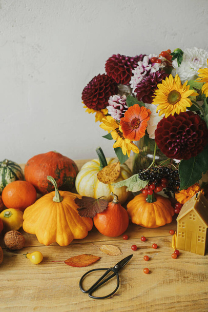 ¡Feliz Día de Acción de Gracias! Elegantes calabazas, flores de otoño, bayas, hojas, velas, tijeras en la mesa de madera rústica en la habitación. Bodegón de otoño atmosférico. Plantilla de tarjeta de felicitación Seasons - Foto, Imagen