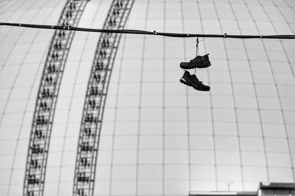Shoes hanging on cable against modern building  - Photo, Image