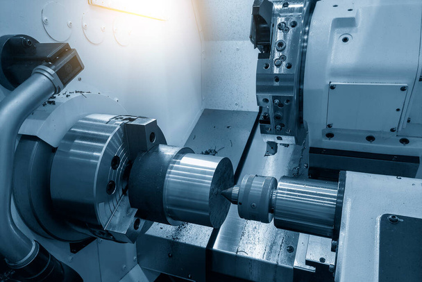 Die CNC-Drehmaschine formt das Schneiden der Metallwellen-Teile. Die hochtechnologische Metallbearbeitung mittels CNC-Drehmaschine . - Foto, Bild