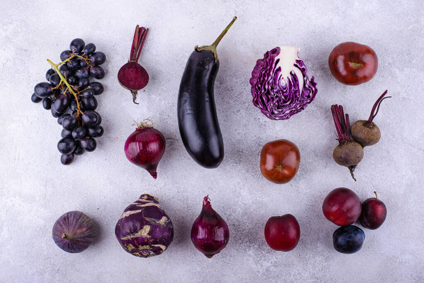 Surtido de verduras y frutas frescas de color púrpura sobre fondo violeta - Foto, imagen