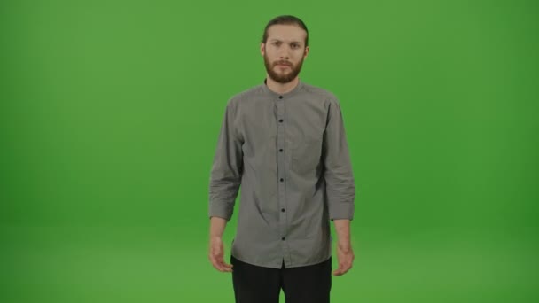 Портрет разгневанного молодого бородатого студента-фрилансера в джинсовой рубашке Эмоционально объясняющий что-то камере размахивая руками на зеленом экране, хрома ключ - Кадры, видео