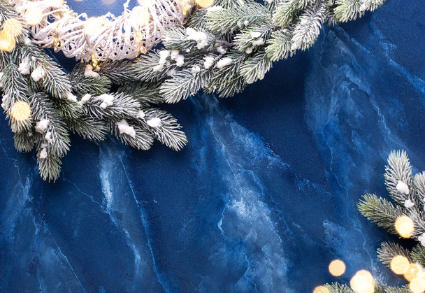 Rahmen aus Zweigen Tanne und Teil auf weißem Kranz auf tiefblauem Hintergrund. Einfache Weihnachtskomposition. Ansicht von oben. Platz für Text.  - Foto, Bild