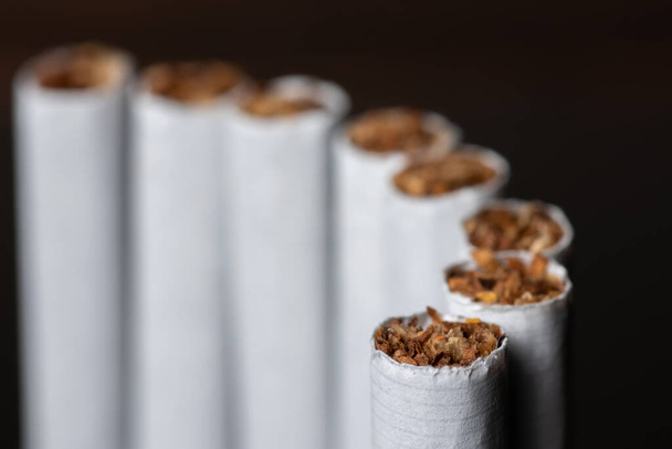 сигарета, сигарета на черном фоне, пачка сигарет, крупный план сигареты. - Фото, изображение