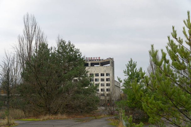 Polissya hotel gezien door hoge bomen op pripyat centrum - Foto, afbeelding