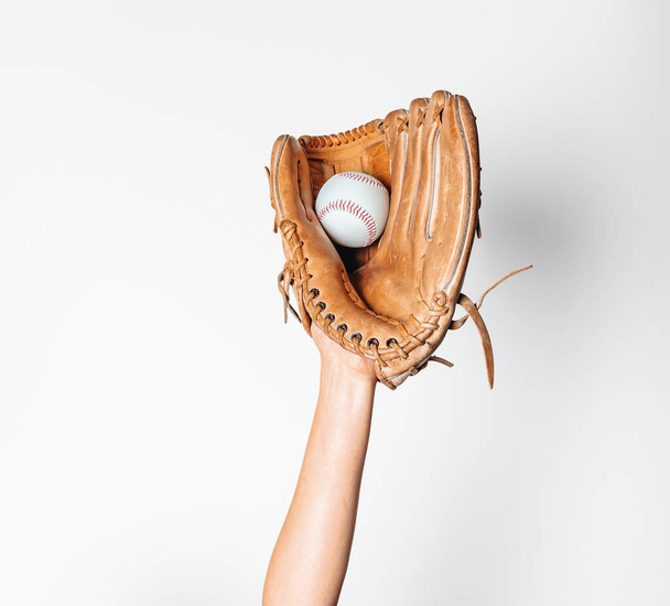 Le baseball est pris dans un gant de baseball usé. - Photo, image