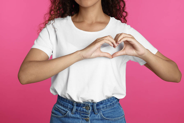 African-American woman making heart with hands on pink background, closeup - Photo, image