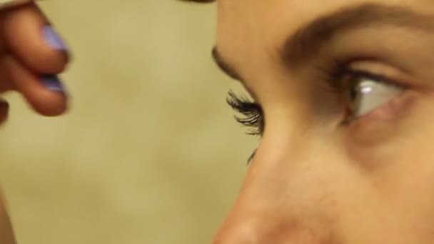 Pretty woman applying make up - Filmati, video
