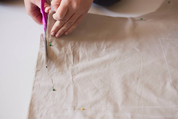 Dressmaker cuts dress detail on the sketch lines. Workplace of seamstress. - Φωτογραφία, εικόνα