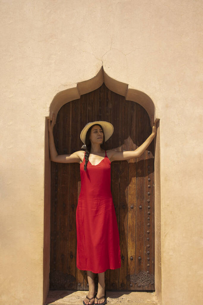 Photograph of a sexy female tourist in the fortress of the Menara gardens of Marrakech enjoying the construction of the ancient Almoravids and their parks, is one of the most visited places in Morocco - Photo, Image