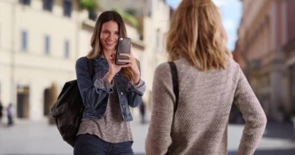 Beyaz kadın Roma, İtalya 'dayken arkadaşının fotoğrafını çekmek için telefon kullanıyor. Arkadaşı telefonuyla fotoğraf çekerken genç beyaz sarışın kadın poz veriyor. 4k - Video, Çekim