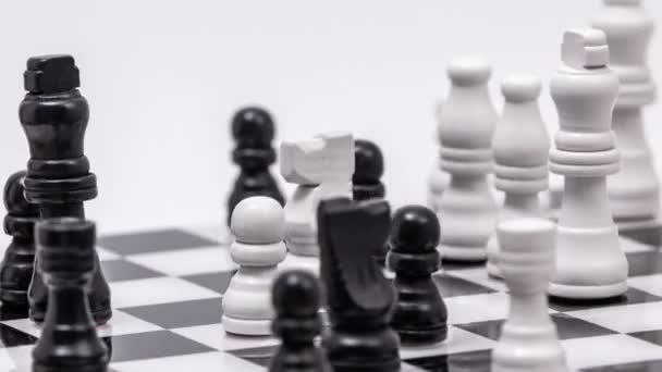 Un tablero de ajedrez a mitad de juego girando sobre un fondo blanco - Metraje, vídeo