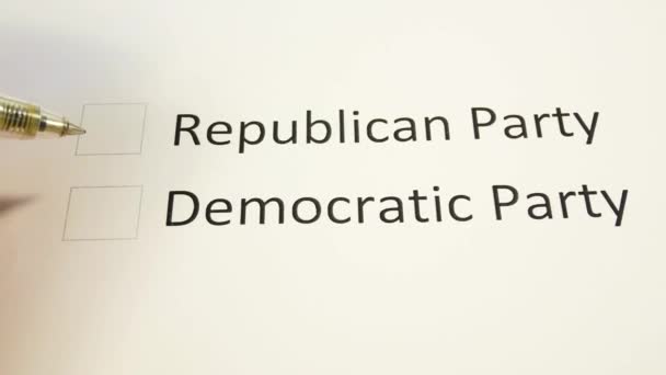 Ruka na hlasovací lístek v listopadových volbách v USA umísťuje ve sloupci Republikánská strana značku pera. Papírové hlasování a modré pero v listopadu. Střednědobé volby do amerického Kongresu - Záběry, video