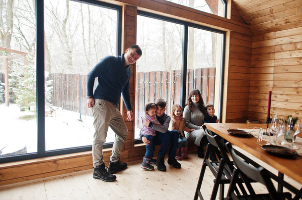 Велика родина в сучасному дерев'яному будинку проводить час разом в теплому і любові
. - Фото, зображення