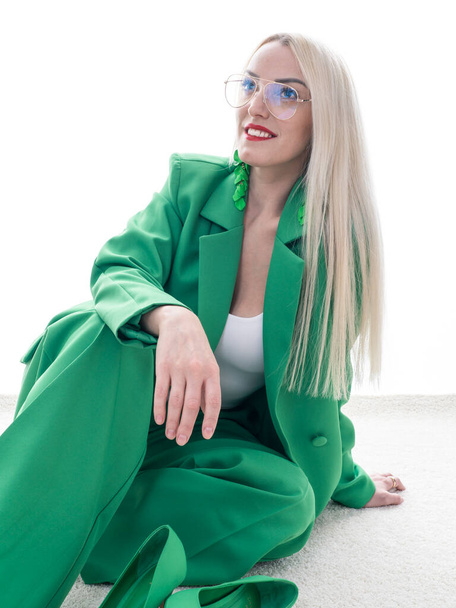 Fashion shot. Green total look. A beautiful blonde woman poses on a white background. Beauty, fashion concept. - Foto, imagen