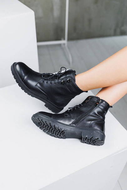 Λεπτά γυναικεία πόδια σε μαύρες χειμερινές δερμάτινες μπότες. Μοντέρνες γυναικείες μπότες. Γυναικεία δερμάτινα υποδήματα. - Φωτογραφία, εικόνα