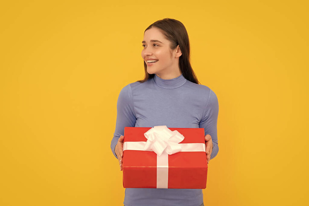 seasonal sales. smiling girl with box on yellow background. boxing day. present and gifts buy. shopping woman with purchase. happy birthday holiday. black friday discount. - Fotografie, Obrázek