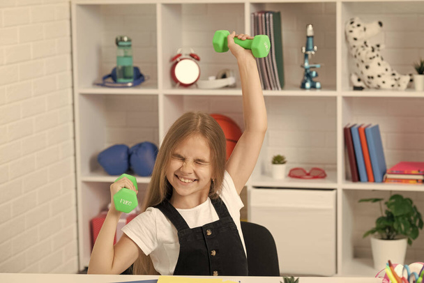 strong child hold barbells in school classroom. - 写真・画像