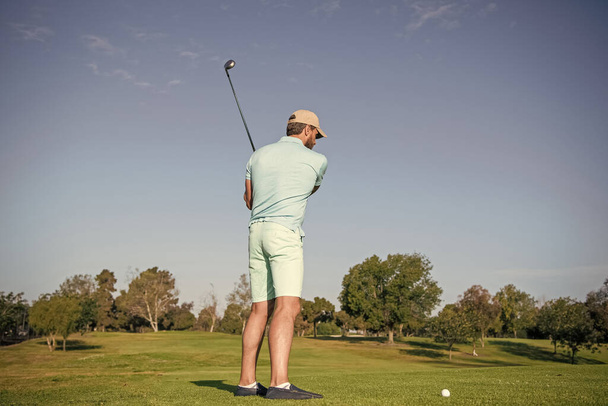 プロゴルフコースの男子ゴルフ選手。ゴルフクラブと一緒にゴルファーの肖像画。人々のライフスタイル。青い空をした緑の芝生でゲームをしてる男。夏のアクティビティ。プロスポーツアウトドア. - 写真・画像