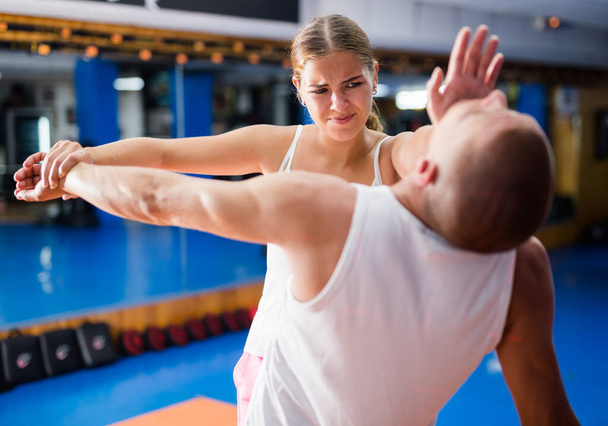 Young woman performing heel palm chin strike on man during self protection training. - Foto, Bild