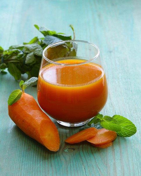 Fresh carrot juice in glass on a wooden table - Photo, Image