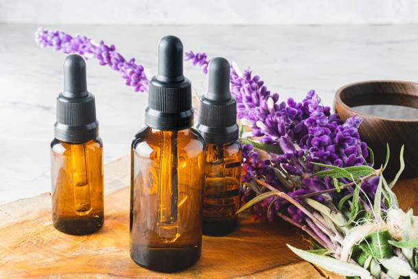 Essential oil dropper bottles with a bouquet of lavender flowers and a cup - Photo, Image