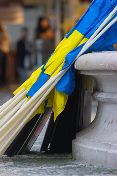 Українські прапори схилилися до колони. Вертикальний постріл - Фото, зображення