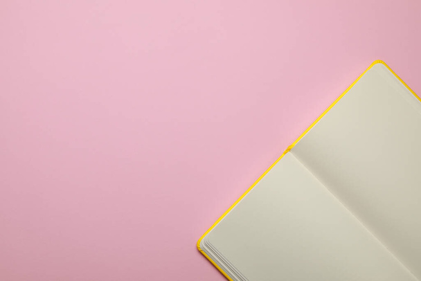 Blanco notitieboekje op lichtroze achtergrond, bovenaanzicht. Ruimte voor tekst - Foto, afbeelding