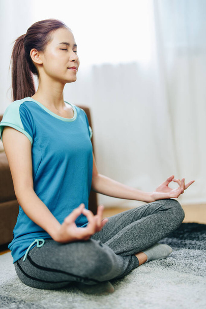 stress relief, muscle relaxation, breathing exercises, exercise, meditation, portrait of Young Asian woman relaxing her body from office work by practicing yoga by watching online tutorials. - Valokuva, kuva
