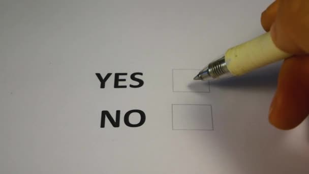 The hand with the pen selects and ticks the YES box on the paper ballot for elections. A paper ballot and a blue pen at a polling station in November. Midterm elections to the U.S. Congress - Footage, Video