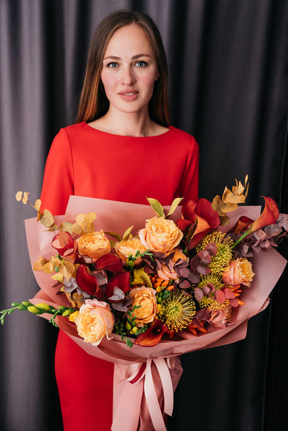 Woman holding orange Autumn Colorful fall bouquet. blooming flowers festive background, autumn orange and red flowers. bouquet floral card. Mothers day, International Womens Day. - Fotografie, Obrázek