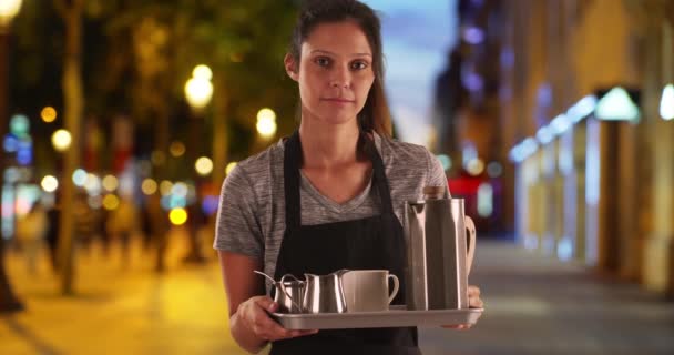 シャンゼリゼの可愛いウエイトレスがコーヒー飲料付きのトレイを運んでいます。エプロンを着た不幸な魅力的な女性と飲み物を提供するトレイを保持します。4k - 映像、動画