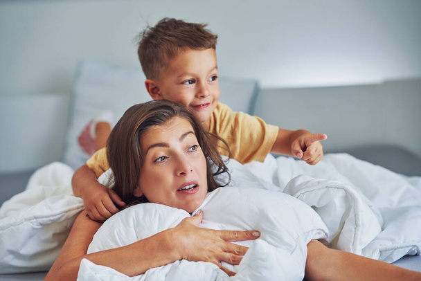 Junge Mutter mit 4-jährigem Sohn im Bett. Hochwertiges Foto - Foto, Bild