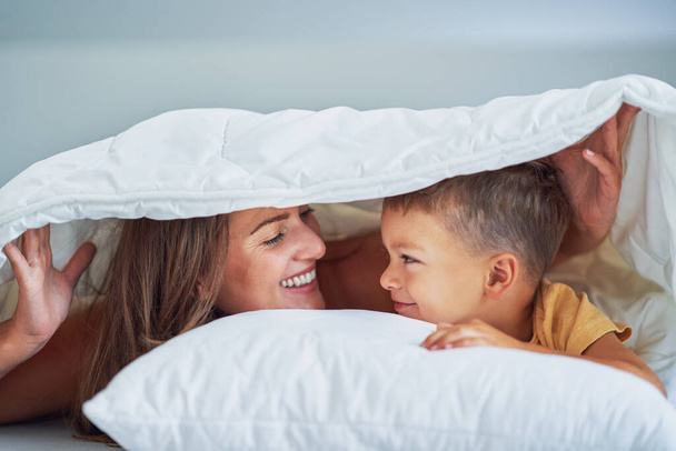 Madre joven con hijo de 4 años en la cama. Foto de alta calidad - Foto, imagen
