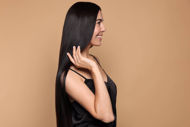 Beautiful young woman with healthy strong hair on beige background - Φωτογραφία, εικόνα