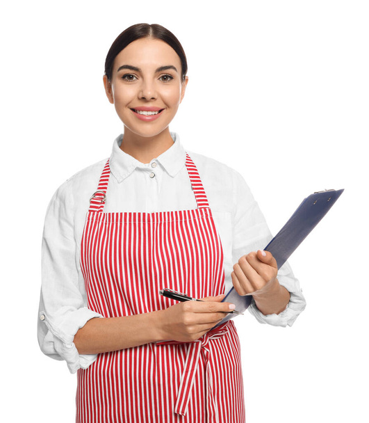 Young woman in red striped apron with clipboard on white background - Фото, изображение
