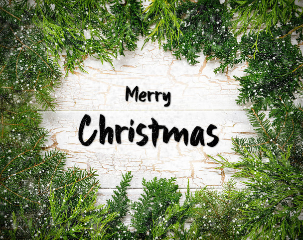 Christmas Card With Fir Branches And English Text Merry Christmas. White Wooden Background With Vintage Design And Snowflakes. - Foto, imagen