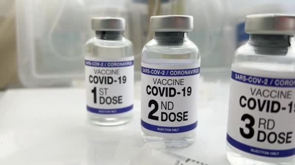 Het Coronavirus vaccin tagde de eerste, tweede, derde en vierde dosis vaccin aan op het etiket. COVID-19 vaccinflacons voor vaccinatie gelabeld met de eerste, tweede, derde en vierde dosis voor boosterinjectie voor omicron-variant - Video